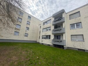 Mehrfamilienhaus mit heller Fassade und Hauseingang in Neukirchen