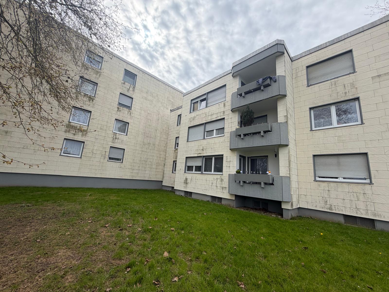 Mehrfamilienhaus mit heller Fassade und Hauseingang in Neukirchen